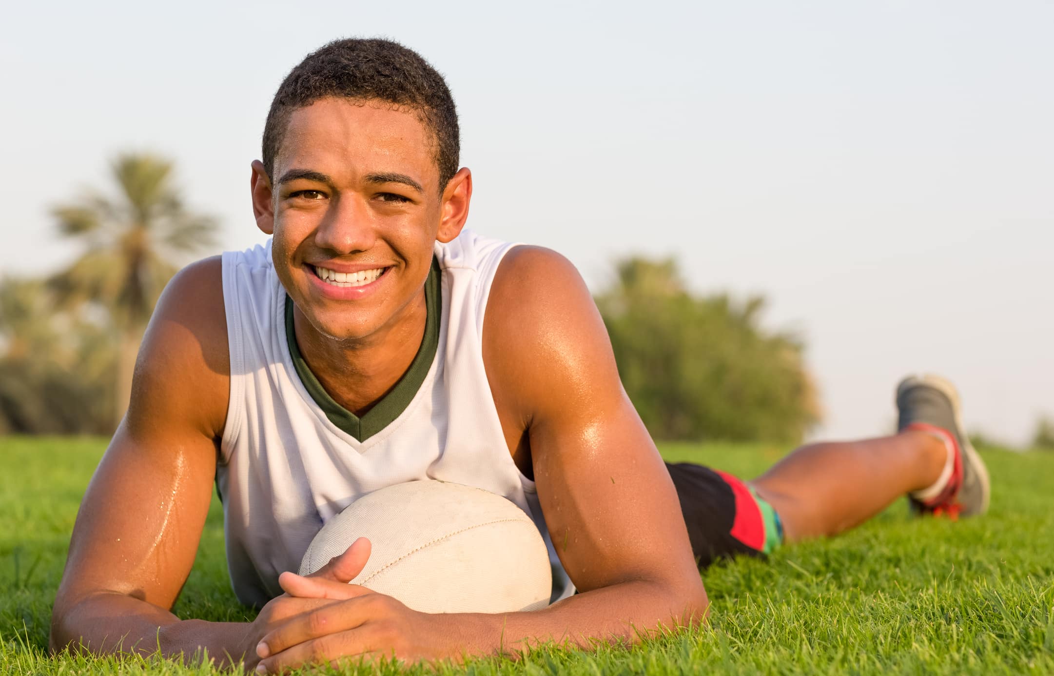 A young athlete smiling brightly with excellent dental health.