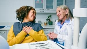 A woman has just had her dentures repaired and expresses gratitude to her dentist. 