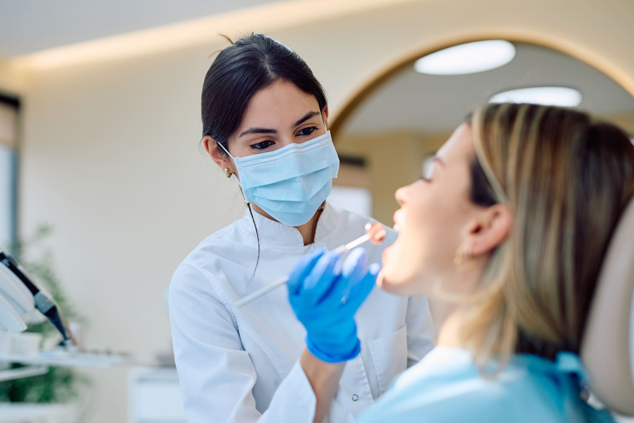 A dental professional examining a patient's gums during a periodontal screening at a dental office.