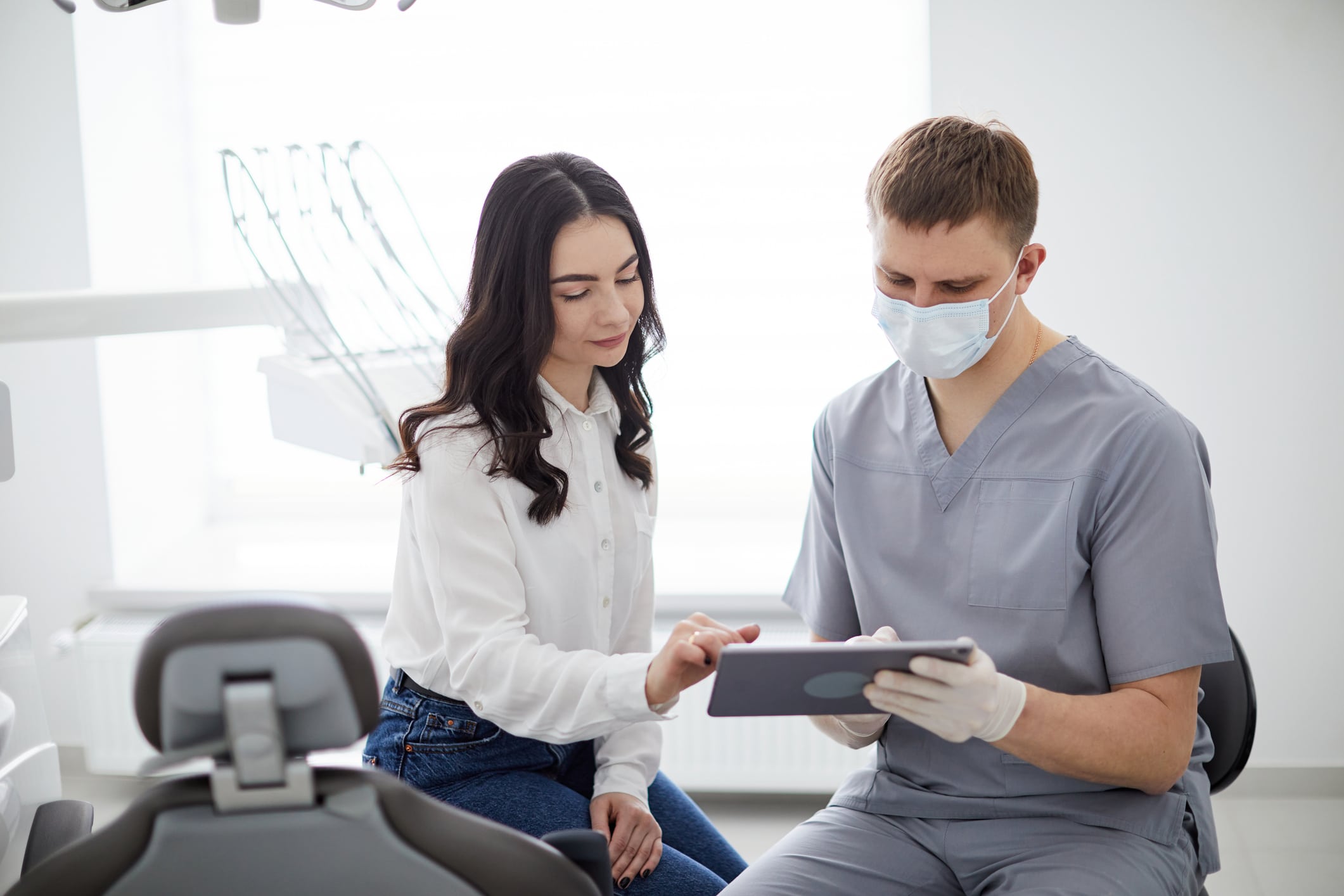 A patient and dentist reviewing denture cost and payment options together at a consultation.